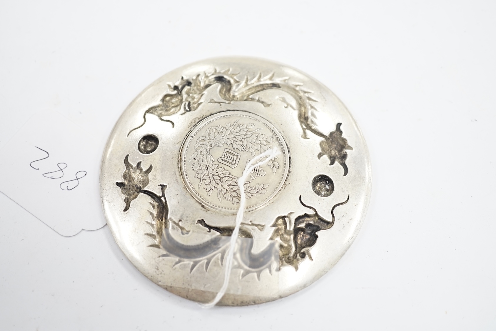 A Chinese white metal dish inset with Yuan Shikai coin, 10.1cm. Condition - fair